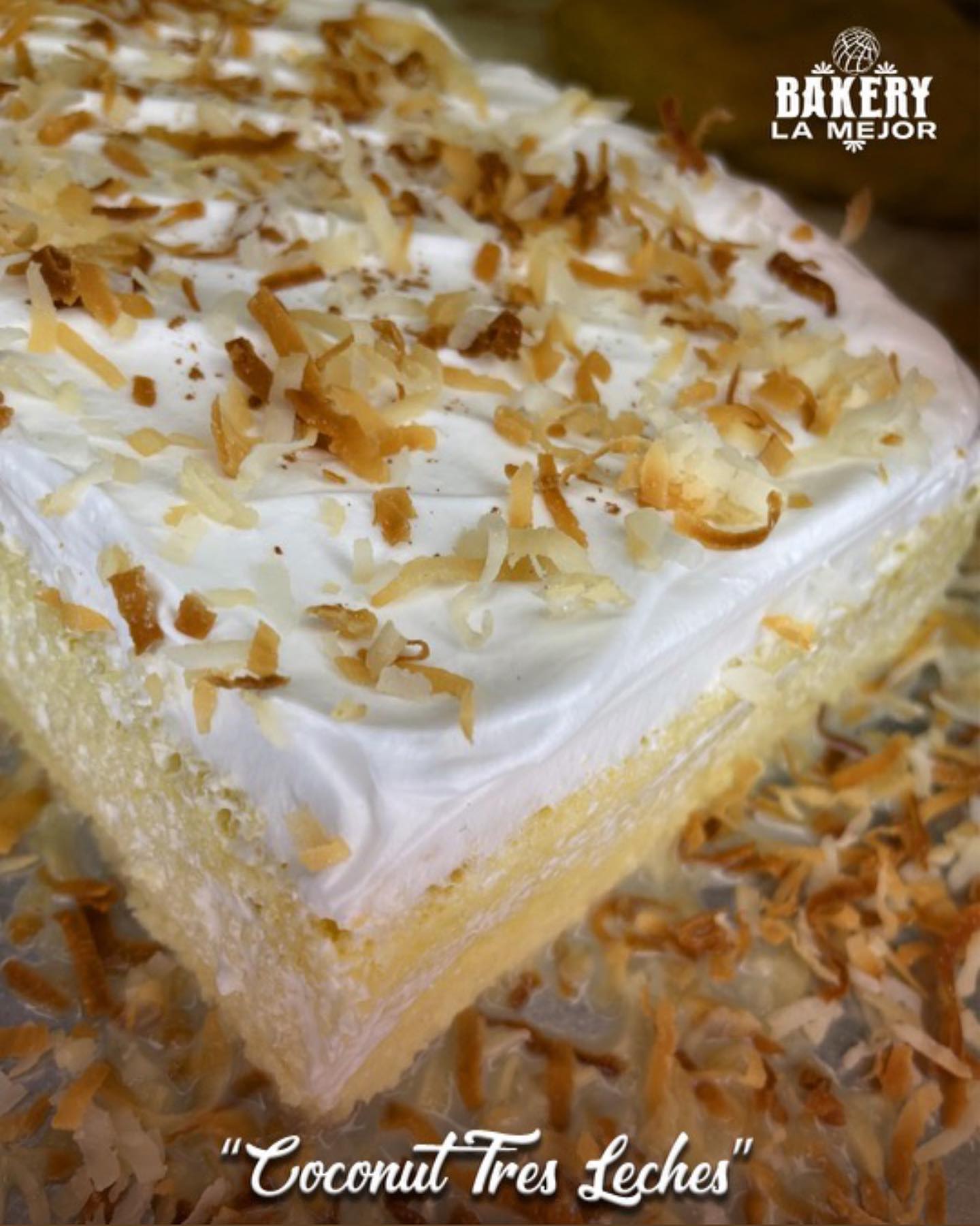 A slice of "Coconut Tres Leches" cake, topped with white cream and toasted coconut flakes, is displayed with a "Bakery La Mejor" logo.
